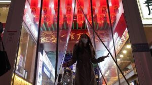 PurnaWarta - Seorang wanita yang mengenakan masker terlihat meninggalkan tempat makan di kota Wuhan, provinsi Hubei, China, pada Kamis (14/1). (AP Photo/Ng Han Guan)