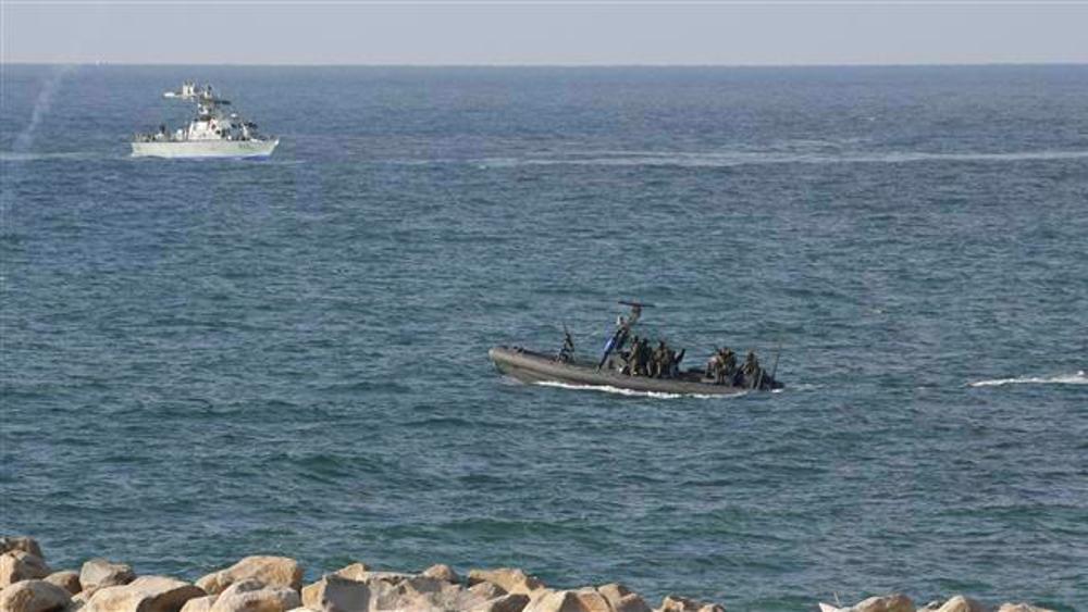 Personel angkatan laut Israel berjaga-jaga dari kapal saat pengunjuk rasa Palestina menggelar demonstrasi di pantai di Jalur Gaza utara.