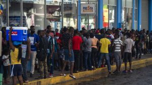 Para migran menunggu bank pengiriman uang dibuka untuk menarik uang yang dikirim oleh kerabat mereka di Tapachula, negara bagian Chiapas, Meksiko, pada 14 September 2021.