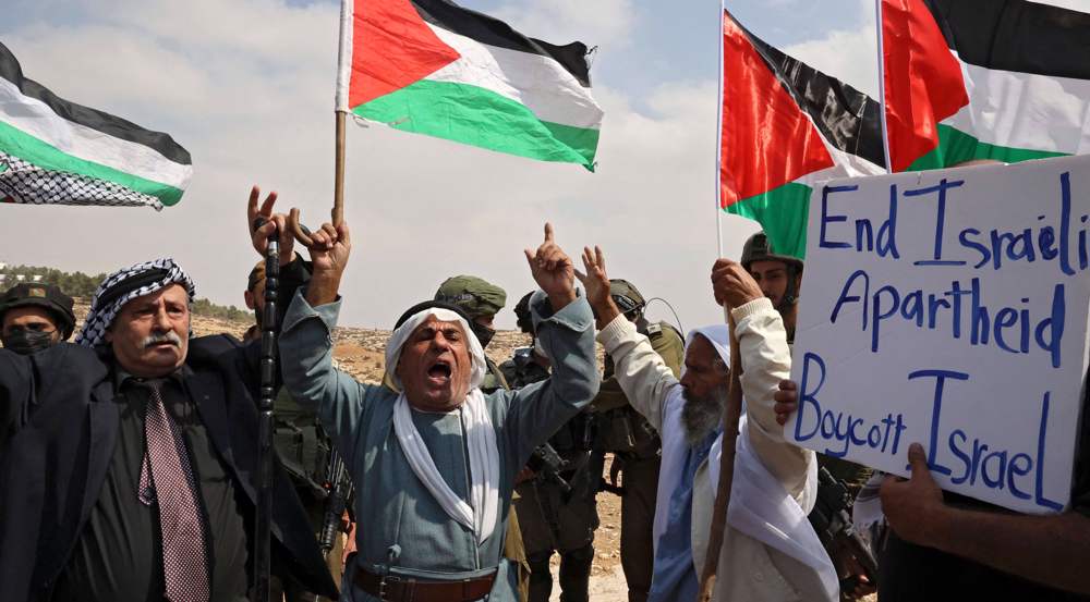 Para lansia Palestina meneriakkan slogan-slogan di depan tentara Israel selama demonstrasi menentang perampasan tanah Israel dan pemotongan pasokan air untuk desa-desa Palestina, di kota al-Khalil, tepi barat selatan pada 2 Oktober 2021.