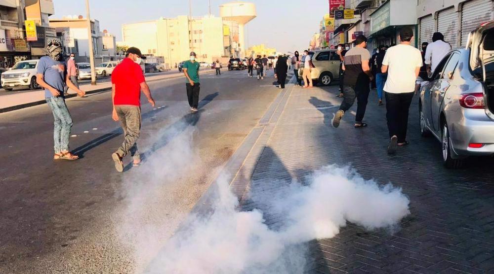 Para pengunjuk rasa menghindari tabung gas air mata di sebuah jalan di Sitra, Bahrain pada 1 Oktober 2021.